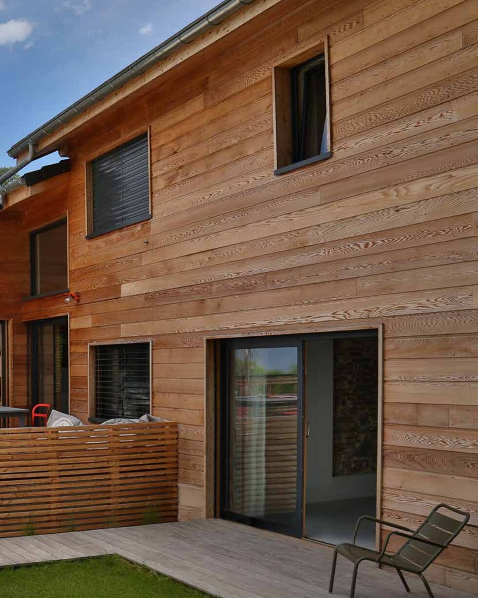 Maison à façade bois et menuiseries extérieures sombres